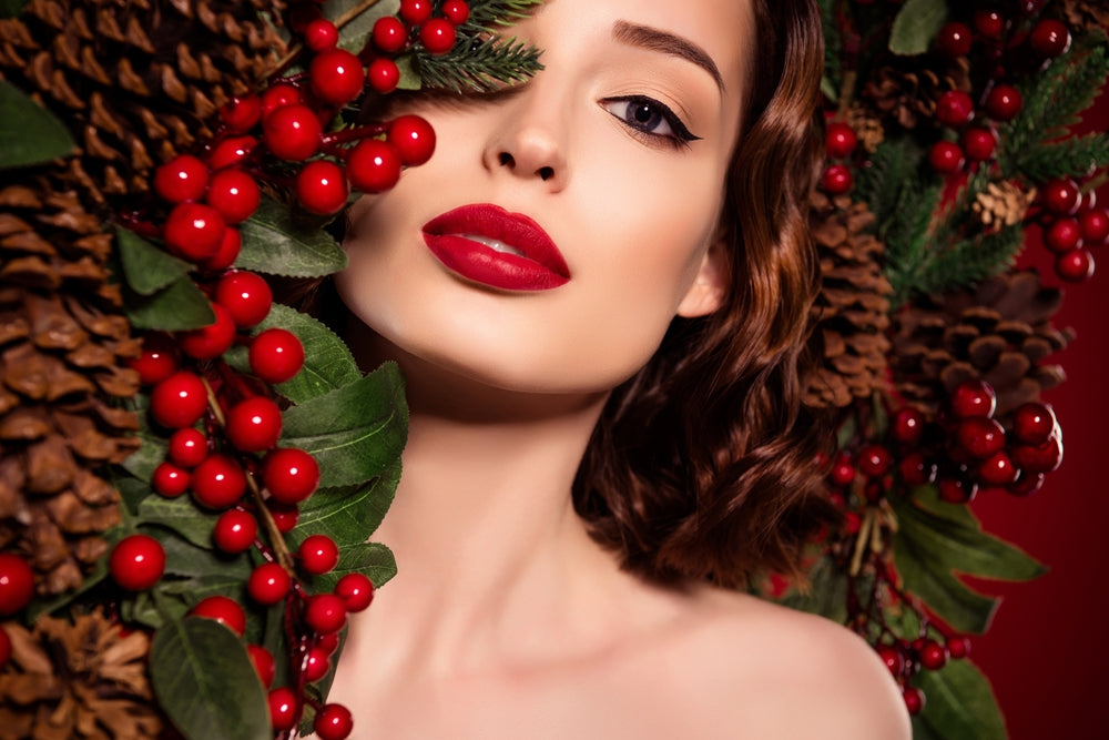 Radiant holiday beauty with glowing skin, framed by a festive wreath-perfect for Christmas Eve inspiration.